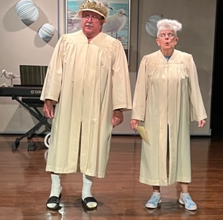 A man and woman in tan graduation gowns