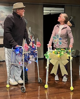 A man and woman with walkers looking at each other