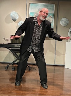 A man in black dress clothes dancing